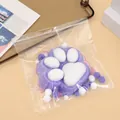 Detail shot of a 14cm purple flocked cat paw squishy toy in clear packaging. - Purple Flocked