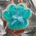 Macro view of blue translucent cat paw squishy with glitter and bow detail - Sea Salt Blue