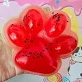 Close-up detail of a translucent watermelon-themed cat paw squishy stress relief toy - Watermelon red