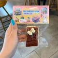 Detailed view of a slow rebound cookie sandwich squeeze toy in its packaging - Cake Bar / Chocolate