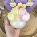 Close-up view of a hand holding a colorful rainbow cat paw squishy toy made of TPR material - 12cm / Jumbo Three-Color Style