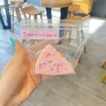 Κοντινή λήψη ενός ροζ παιχνιδιού squishy προσομοίωσης τούρτας σε διαφανή σακούλα - Τριγωνικό Τυρί / Ροζ