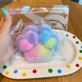 Detailed view of a colorful rainbow cat paw squishy stress toy in a transparent bag - Iridescent