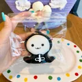 Close-up view of a cute ghost-shaped Halloween squishy toy in clear plastic packaging. - Grim Reaper / 7.5x7.5cm