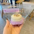 Detailed view of realistic Basque cheesecake squishy toy in cute packaging - Crepe Cake / Purple