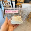 Close-up of a realistic Basque cheesecake squishy toy inside a clear zipper packaging bag - Crepe Cake / Blue