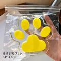 Primer plano de un juguete squishy gigante de pata de gato amarilla de 14 cm en su empaque - Pata de Gato Grande (Superficie Lisa) / 14cm / Amarillo Transparente