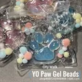 Soft glittery blue cat paw squeeze toy with colorful pom-poms in transparent packaging - Transparent Blue Cat Paw