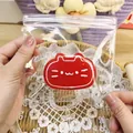 Close-up of red cat-shaped slow rebound squishy toy inside a clear protective zip-lock bag - Watermelon - Cheese Cat (Painted Style)