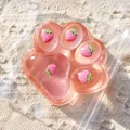 Close-up of pink translucent cat paw squishy toy with embedded strawberry charms - Strawberry Inlaid Style / 230g / Transparent Pink