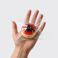 Λεπτομέρεια του ρεαλιστικού παιχνιδιού squishy σουφλέ με μύρτιλα σε διαφανή σακούλα. - Κόκκινο σουφλέ βατόμουρου