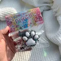 Vue détaillée d'un jouet squishy en forme de patte de chat avec paillettes dans son emballage - Style Flocage / Noir et Blanc