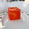 Orange translucent maltose ice cube squishy fidget toy on a white decorative plate - 5cm / Orange Marble