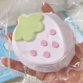 Detailopname van een aardbeivormige siliconen squishy in een plastic verpakking. - Roze Grote Aardbei