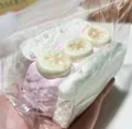 Detailansicht eines realistischen Squishy-Toastkuchens mit Sahnetextur und Bananenscheiben. - Kirschblütenrosa Bananenscheiben-Sandwich