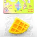 Detailansicht eines gelben Käse-Waffel-Squishy-Spielzeugs in der Originalverpackung - Fried Dreieckswaffel Stil