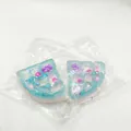 Detailansicht von zwei blauen Waffel-Squishies mit Bären- und Herzglitzer in einem Beutel - Zufällige Farbe / Meersalz Glitzer Dreieckswaffel Stil