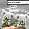 Detailed view of the 93g grey flocked koala squishy toy with decorative palm tree - Exquisite Grey Pearl Koala Hugging Tree with Green Fur / 9*9