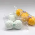 Vue détaillée des jouets spongieux Mochi Daifu dans une boîte de présentation verte. - Ensemble de 2 Pièces / Donuts à la noix de coco