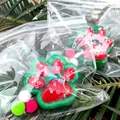 Close-up of Christmas cat paw squishy toy in clear packaging with festive glitter - Christmas Series / Christmas Red and Green
