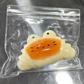 Croissant-shaped frog squishy stress relief toy in a transparent bag - Caramel Croissant Squishy