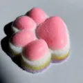 Primo piano di un giocattolo squishy a zampa di gatto arcobaleno con morbida texture floccata - Modello B: Squishy jumbo 12 cm a 4 strati (floccato)