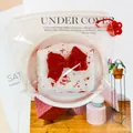Close-up of food-grade silicone cream cake squishy toy in clear zipper bag - Toast with Bow