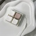 Close-up of a 4-grid keyboard switch tester fidget keychain on a white ceramic tray - Coconut Latte