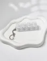 Close-up of 4-key transparent mechanical switch tester keychain on white tray - White