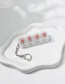 Detail view of a 4-key mechanical switch tester fidget keychain with transparent pink keycaps - Pink