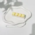 Close-up of a 4-key mechanical keyboard fidget toy keychain on a white tray - No Light - Blue Switch Mechanical Sound / Goose Yellow