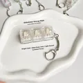 Gedetailleerde weergave van de 3-toets mechanische schakelaar fidget sleutelhanger - Jasmijnwit (Tactiele Schakelaars)