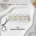 Close-up of four ice-clear mechanical tactile switch keychain in jasmine white - Cream