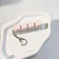 Decompression fidget keyboard switch keychain with 4 light pink keys on white wave plate - 4-Key Layout / Sakura Pink
