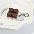 Close-up detail of a cute chocolate cat ear keycap fidget toy on a white ceramic plate - 4-Key Layout (Crispy Tactile Sound) / Cocoa Dream
