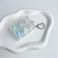 Vue détaillée d'un porte-clés fidget toy à 6 touches en PC transparent et coloré. - Océan glaciaire - couleurs et commutateurs mixtes