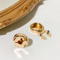 Detailopname van luxe goudkleurige koperen speldsluitingen op een wit glanzend oppervlak. - 17.5mm / Plat KC Goud
