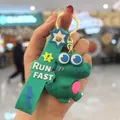 Détail d'un porte-clés dinosaure 3D vert mignon avec une dragonne marquée RUN FAST - Dinausore mignon / Vert foncé
