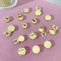 Gouden koperen vlindersluitingen en speldachterkantjes op roze getextureerde achtergrond - 17.5mm / Platte Koperen Blank