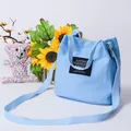 Casual light blue canvas bucket bag with shoulder strap and Living Travelin Share text - Light Blue