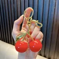 Close-up of cherry keychain bag charm with red finish and gold-tone metal clasp. - 3cm / Solid Red Gold Rod