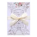 Macro view of intricate laser-cut floral patterns on white wedding invitation with cream bow - White (White Inner Pages)
