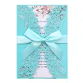 Detailed view of teal laser-cut wedding invitation card featuring elegant satin bow - Tiffany Blue