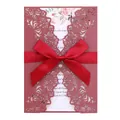 Elegant burgundy laser-cut wedding invitation card with a red satin ribbon bow detail. - Dark Red