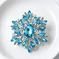 Vue détaillée d'une grande broche flocon de neige en cristal bleu sur assiette blanche - Argent et bleu clair