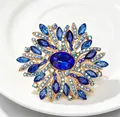 Gros plan détaillé d'une grande broche fleur en cristal bleu avec base en alliage doré - Bleu