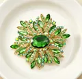 Détail d'une élégante broche fleur en cristal vert avec alliage doré et de faux strass - Vert