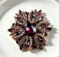 Macro view of an elegant purple crystal flower brooch with sparkling iridescent rhinestones - Purple