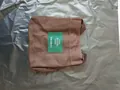 Compact brown canvas bucket bag featuring a green label with minimalist white text - Coffee