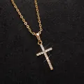 Primo piano di un ciondolo a croce dorato con scintillanti pietre di zirconi cubici - Stile con Intarsio di Strass / Oro